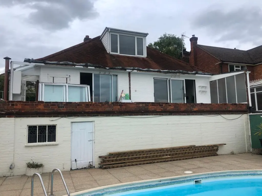 Existing hillside house and pool before construction